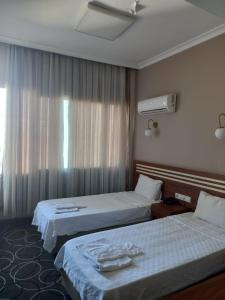 um quarto de hotel com duas camas e uma janela em Aksoy Otel em Adana