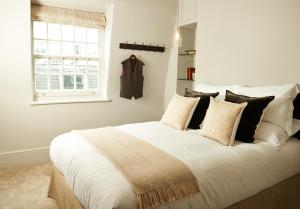 
a bedroom with a white bedspread and pillows at The Bull and The Hide in London
