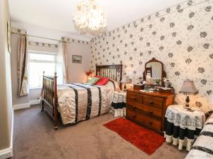 Llanfihangel-y-pennantにあるYmwlch Bach Farmhouseのベッドルーム1室(ベッド1台、ドレッサー、鏡付)