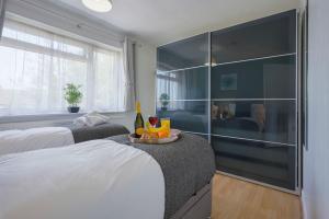 a bedroom with two beds and a glass wall at 5 Bedroom Detached House - Close to City Centre - Sleeps up to 10 guests with Free Parking, Fast Wifi, SmartTVs and Large Garden by Yoko Property in Milton Keynes