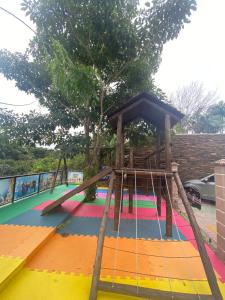 a playground with a slide and a swing at Pousada Bella Casa in Balneário Camboriú