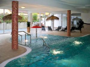 a large swimming pool in a hotel with columns at Holiday Home Schwan by Interhome in Granzow