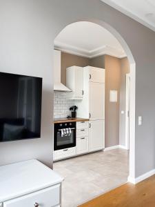 een keuken met witte kasten en een tv. bij Prorsus Apartment Design in Leipzig