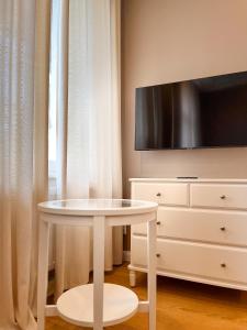 een witte tafel voor een tv en een dressoir bij Prorsus Apartment Design in Leipzig