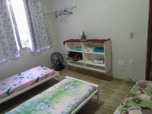 a room with two beds and a cabinet in it at Apartamento Anchieta 7 Belo in Rio de Janeiro