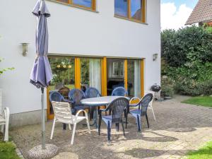 a patio with a table and chairs and an umbrella at Holiday Home Müritz Ferienpark Röbel-22 by Interhome in Röbel