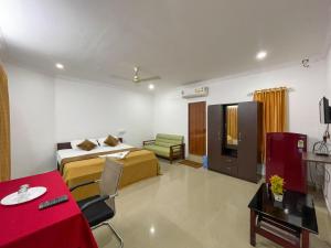 a hotel room with a bedroom with a bed and a table at AWA Residency in Cochin