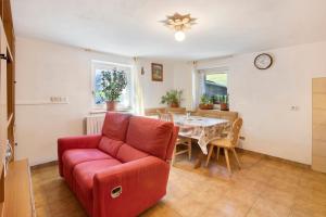 uma sala de estar com um sofá vermelho e uma mesa em Casa Valentina em Livigno