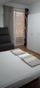 ein weißes Bett in einem Zimmer mit Fenster in der Unterkunft Apartment, sweet home in the town-center. in Bitola