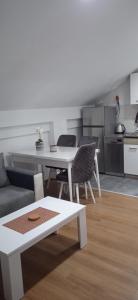 ein Wohnzimmer mit einem weißen Tisch und Stühlen in der Unterkunft Apartment, sweet home in the town-center. in Bitola