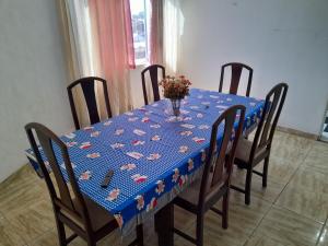 a table with a blue table cloth with a vase of flowers at Apartamento Anchieta 7 Belo in Rio de Janeiro