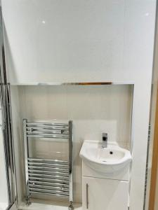 a white bathroom with a sink and a shower at Modern 2 Bedroom Apt Derby City in Derby