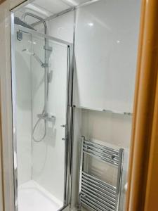 a shower with a glass door in a bathroom at Modern 2 Bedroom Apt Derby City in Derby