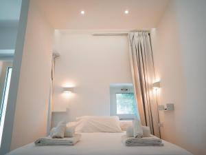 a white bed with two towels on top of it at Villa Ada Olbia in Olbia +79 photos