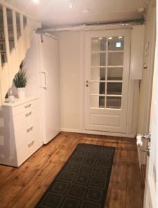 a room with a white door and a wooden floor at Studioleilighet i kjeller ved stranden og hvalsenter NB Må vaskes etter endt leie eller betale rengjøringshjelpen 500 kr in Andenes
