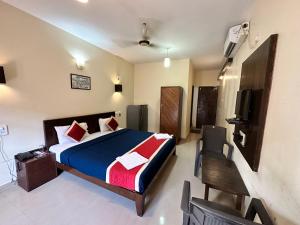 Hotel Salty Waves Baga في باغا: غرفة نوم بسرير وتلفزيون في غرفة