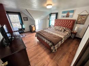 ein Schlafzimmer mit einem großen Bett und Holzböden in der Unterkunft Spacious Duplex In The Heart Of Downtown Plymouth in Plymouth