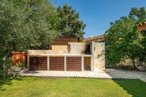 a house with brown doors in a yard at Casa Cò in Costa Rei