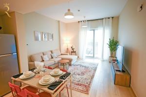Champagne pink Apartment - Yas Island في أبوظبي: غرفة معيشة مع طاولة وأريكة