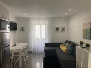 a living room with a couch and a table and a kitchen at Cantinho das Flores II in Nazaré