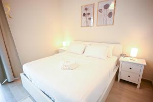 a bedroom with a white bed and a night stand at Champagne pink Apartment - Yas Island in Abu Dhabi