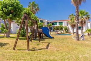 a park with a playground with a slide at Villa Elfa in Cala en Forcat