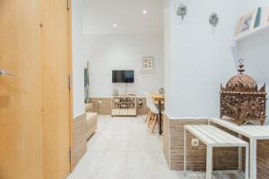 ein Wohnzimmer mit einem Tisch und einem TV in der Unterkunft Beautiful and cozy- 1Bd 1Bth- Arenal Center in Sevilla