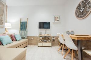 ein Wohnzimmer mit einem Sofa und einem Tisch mit Stühlen in der Unterkunft Beautiful and cozy- 1Bd 1Bth- Arenal Center in Sevilla