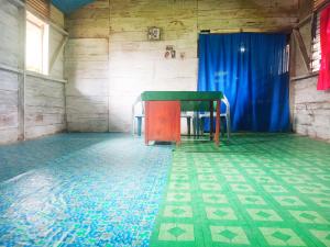 Habitación con mesa y cortina azul en Simple Cozy Room in Buntumalangka', 