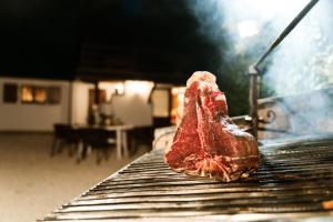 a piece of meat sitting on top of a grill at DOLF - Villa Ombrosa in Isola