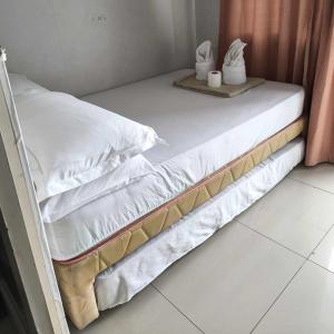 ein Bett mit weißer Bettwäsche und Kissen darauf in der Unterkunft Sea Residence Finest in Manila