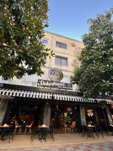 un restaurante con mesas y sillas frente a un edificio en Sol Hotel en Shkodër