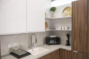 a kitchen with a sink and a microwave at STAY Glam Skin Studio in Nicosia