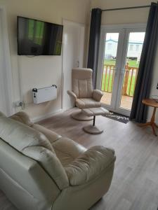 a living room with a couch and a chair and a television at Immaculate 2-Bed Apartment in Mablethorpe in Mablethorpe