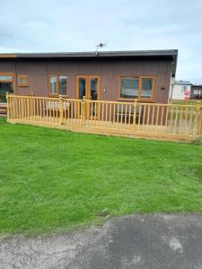 a house with a wooden deck and a yard at Immaculate 2-Bed Apartment in Mablethorpe in Mablethorpe