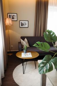 a living room with a couch and a table at Hotel Säntis in Munich