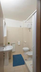 baño con lavabo, aseo y alfombra azul en Il BORGOIN, en Barrea