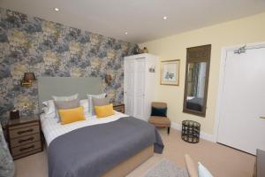 a bedroom with a large bed with yellow pillows at The Grasmere Hotel in Grasmere