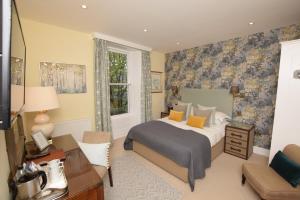- une chambre avec un lit et un bureau dans l'établissement The Grasmere Hotel, à Grasmere