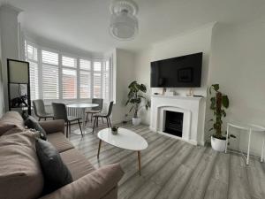 a living room with a couch and a fireplace at Spacious Modern Flat in Mitcham in Mitcham