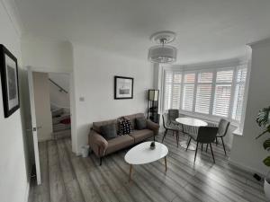 a living room with a couch and a table at Spacious Modern Flat in Mitcham in Mitcham