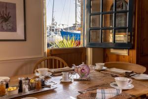 a dining room table with a view of a boat at Britannia House in Lymington
