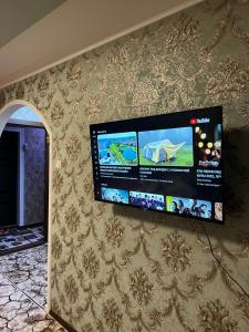TV de pantalla plana colgada en la pared en Welcome TJ Apartment en Khujand