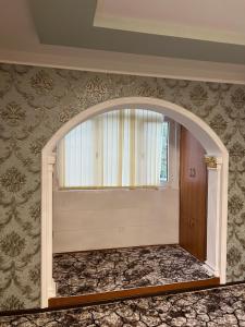 Un arco en una habitación con ventana en Welcome TJ Apartment en Khujand