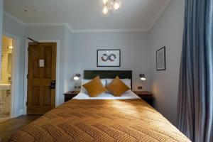 a bedroom with a large bed with orange pillows at THE KNIGHT OF NOTTINGHILL in London