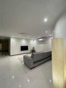 a living room with a couch and a flat screen tv at شقة فاخرة بقفل ذكي - Luxury apartment in Riyadh
