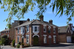 an old red brick house with a green door at Britannia House in Lymington