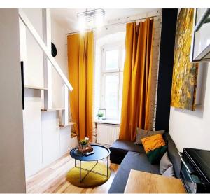 salon z kanapą i stołem w obiekcie Jaracza 6 Studio15 w Łodzi