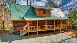 a large wooden cabin with a green roof at Relax & Unwind Hot-Tub 6 seater, Fire-Pit, Master King Bed, Near Wineries, Resort Amenities in Ellijay
