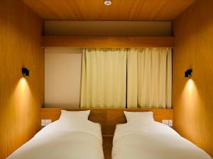 2 nebeneinander sitzende Betten in einem Schlafzimmer in der Unterkunft Lake Side Inn MIRAHAKONE in Moto-hakone